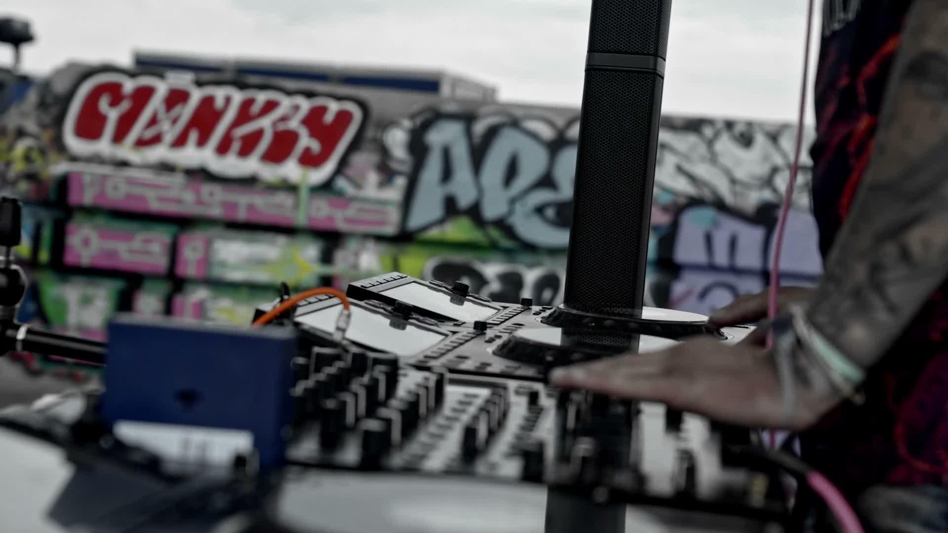 DJ booth on a rooftop in front of a graffiti wall